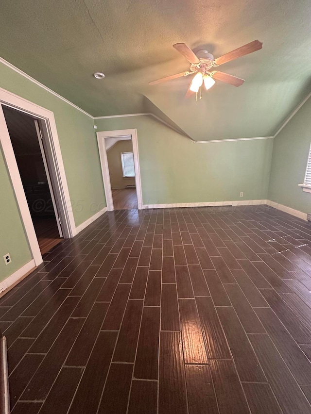 bonus room with dark wood-type flooring, baseboards, ceiling fan, vaulted ceiling, and a textured ceiling
