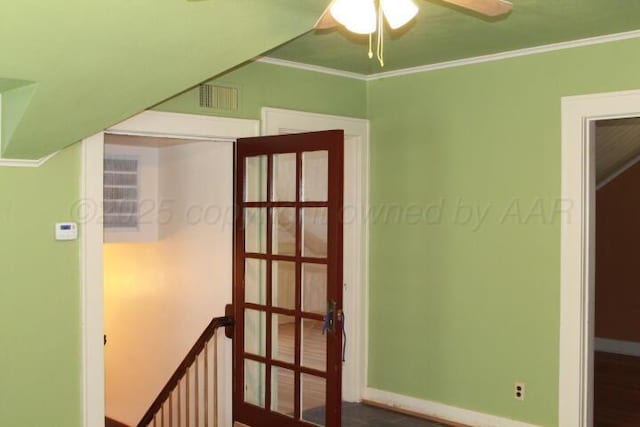 interior space with visible vents, baseboards, ornamental molding, and a ceiling fan