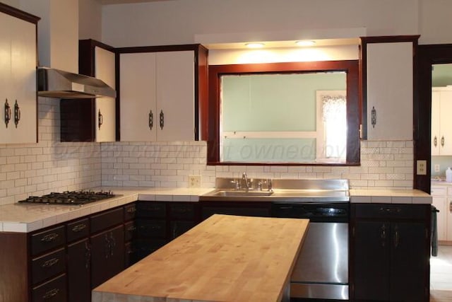 kitchen with a sink, gas cooktop, wall chimney range hood, decorative backsplash, and dishwasher