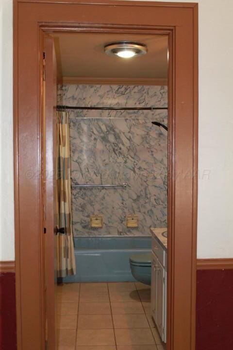 full bathroom featuring tile patterned floors, toilet, vanity, and shower / bath combo