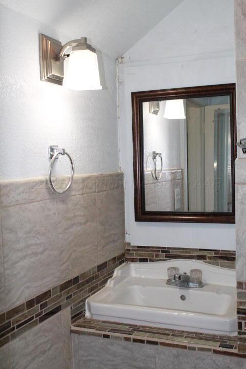bathroom featuring lofted ceiling and a sink