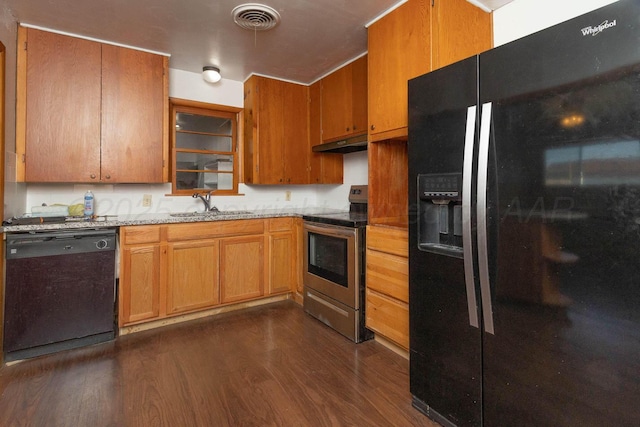 kitchen with dark wood-type flooring, light stone countertops, sink, and black appliances