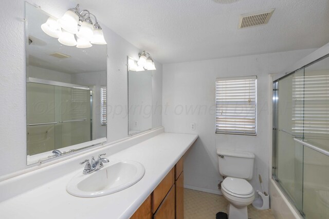 1209 S Main St, Shamrock, TX 79079 - bathroom with vanity, enclosed tub / shower combo, and a textured ceiling