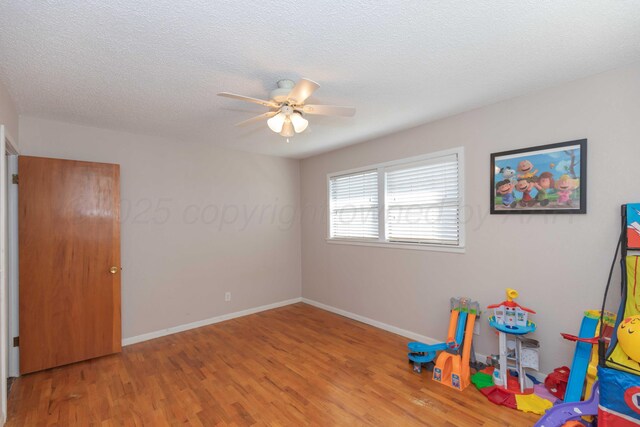 1209 S Main St, Shamrock, TX 79079 - rec room with wood finished floors, ceiling fan, and a textured ceiling