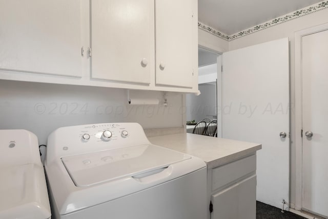 washroom featuring washing machine and clothes dryer and cabinets