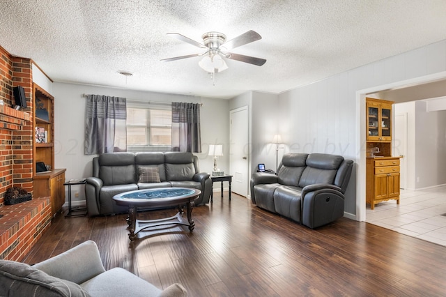 living room featuring hardwood / wood-style floors, ceiling fan, and a textured ceiling