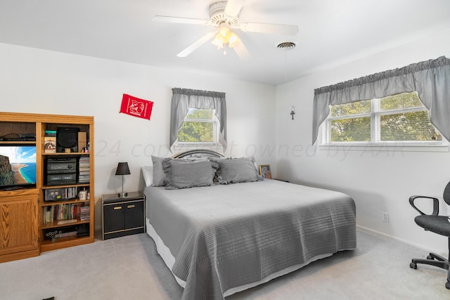 bedroom featuring light carpet, multiple windows, and ceiling fan