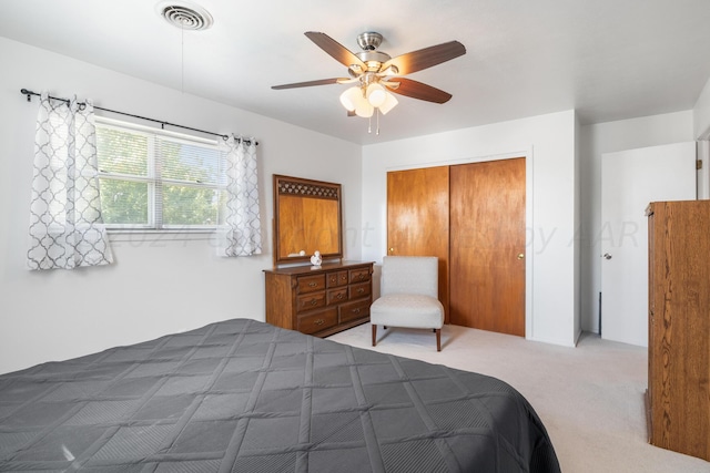 carpeted bedroom with ceiling fan and a closet