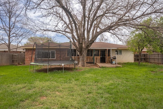 3412 Sunlite St, Amarillo, TX 79109 - rear view of house with a trampoline, a fenced backyard, a wooden deck, and brick siding