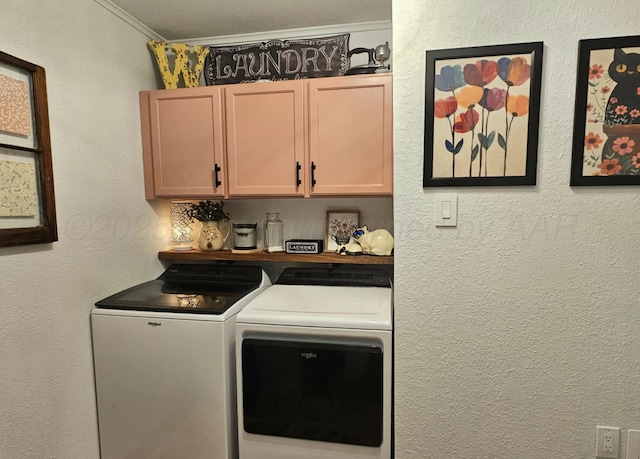 laundry area with a textured wall, cabinet space, crown molding, and washing machine and clothes dryer