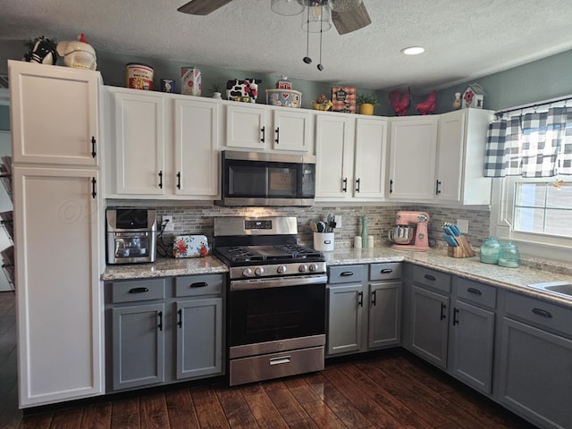 kitchen with gray cabinets, appliances with stainless steel finishes, ceiling fan, and dark wood-style flooring