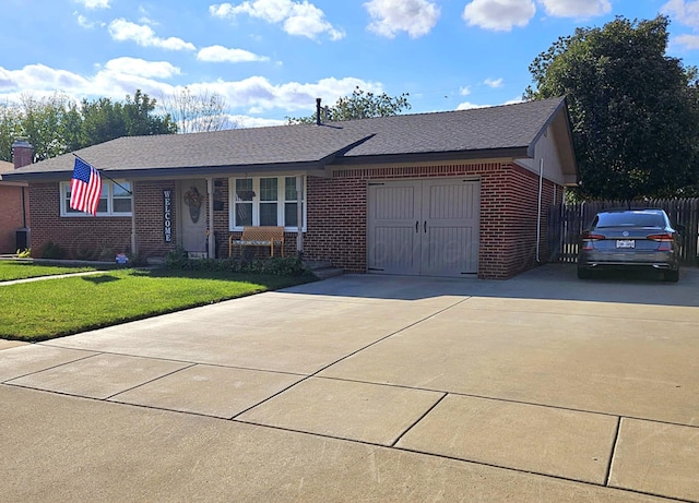 single story home featuring brick siding, an attached garage, concrete driveway, and a front lawn