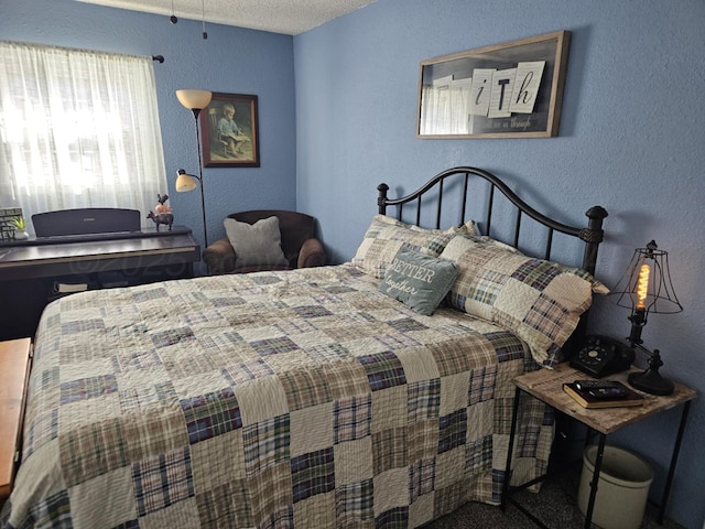 bedroom featuring a textured wall and a textured ceiling