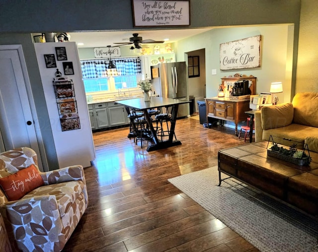 living room featuring dark wood finished floors and a ceiling fan