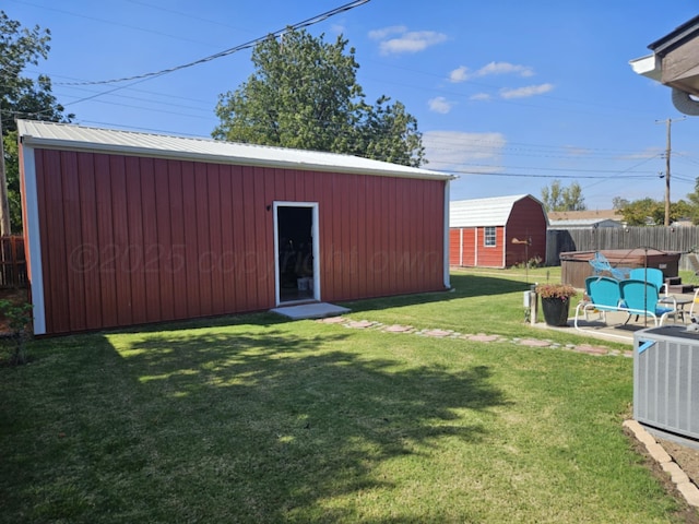 exterior space with an outbuilding, central AC unit, and fence