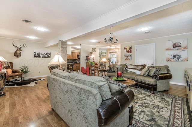 2229 Charles St, Pampa, TX 79065 - living room featuring wood finished floors, crown molding, and a chandelier
