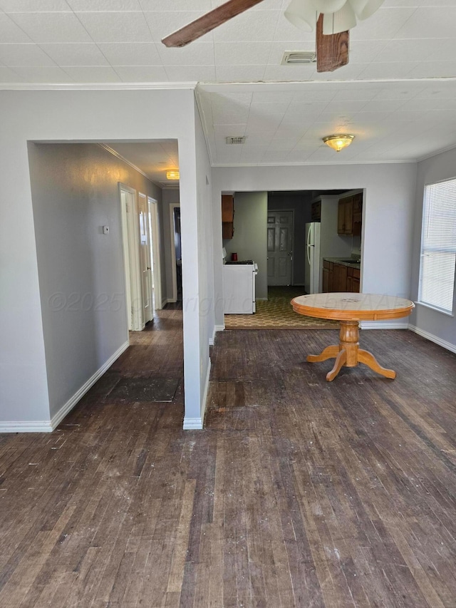 unfurnished dining area featuring dark hardwood / wood-style flooring and crown molding