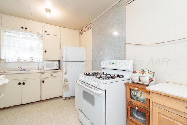 1441 NW 14th Ave, Amarillo, TX 79107 - kitchen with light countertops, a sink, wallpapered walls, and white appliances