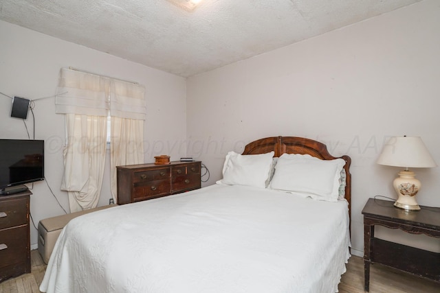 1441 NW 14th Ave, Amarillo, TX 79107 - bedroom with a textured ceiling and wood finished floors