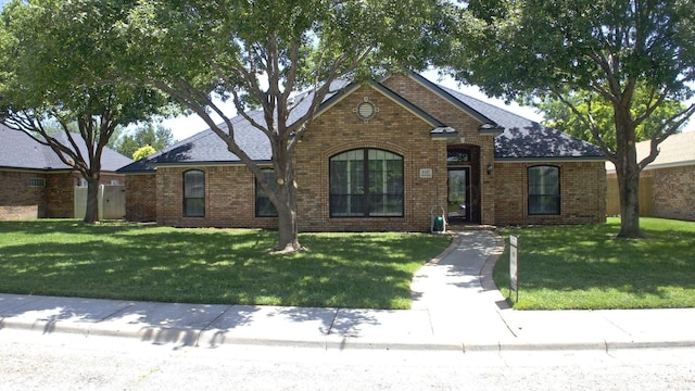 8107 Progress Dr, Amarillo, TX 79119 - view of front of house featuring brick siding, a front yard, and a shingled roof