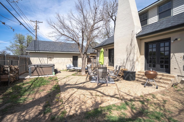 exterior space with fence, a hot tub, and a patio area