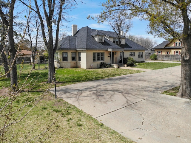view of front of home featuring a chimney, fence, stucco siding, and driveway