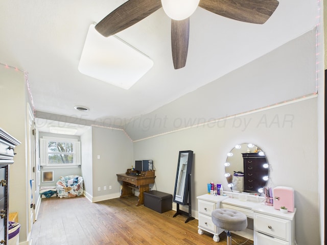 office space with lofted ceiling, ceiling fan, visible vents, baseboards, and wood finished floors