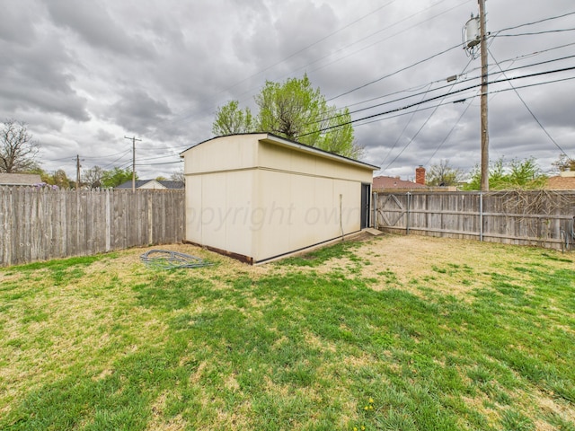view of yard with a fenced backyard and an outbuilding