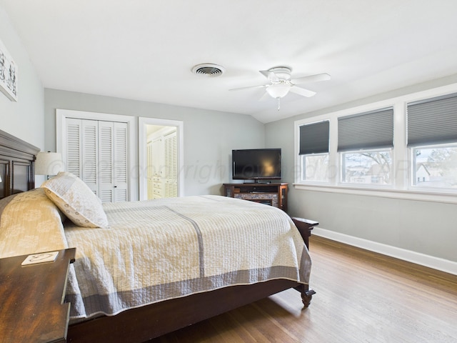 bedroom with baseboards, visible vents, wood finished floors, and ceiling fan