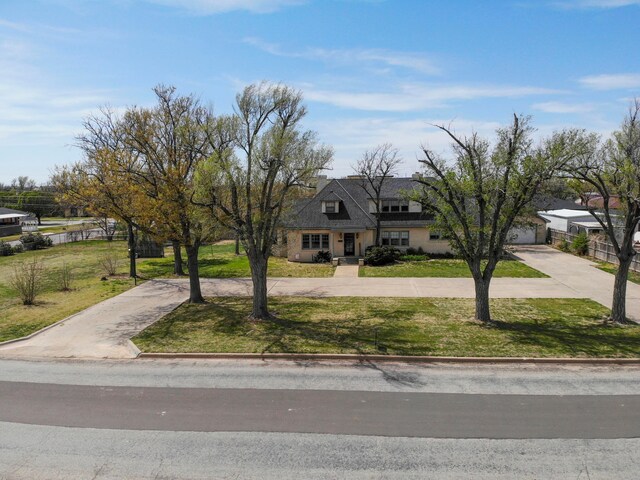 view of front facade with a front lawn and curved driveway