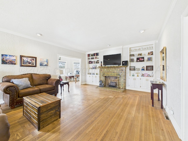living room with light wood-style flooring, ornamental molding, built in shelves, a fireplace, and baseboards