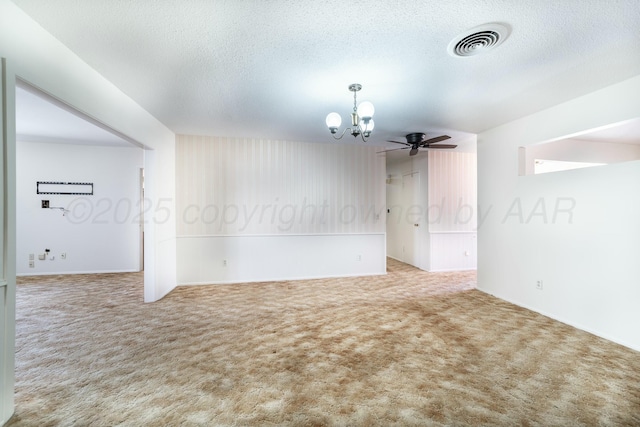 carpeted spare room featuring visible vents, a textured ceiling, and ceiling fan with notable chandelier