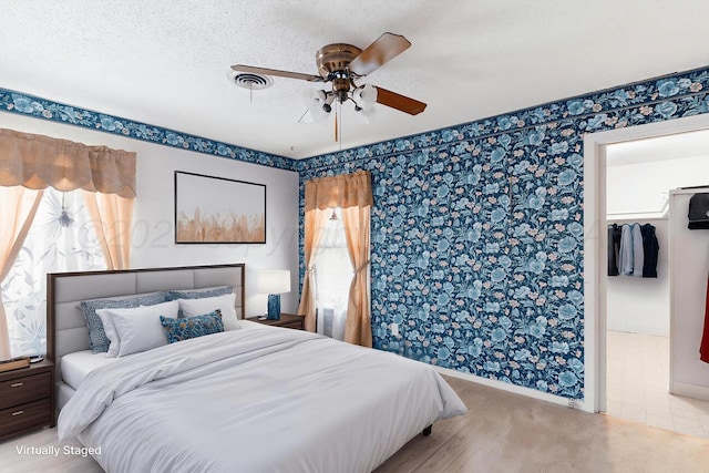 1338 Haggard St, Borger, TX 79007 - bedroom with visible vents, a ceiling fan, a walk in closet, baseboards, and wallpapered walls