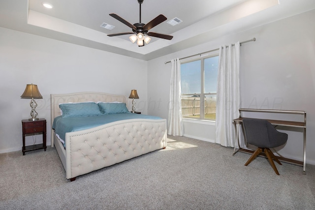 bedroom featuring a tray ceiling, carpet flooring, and baseboards