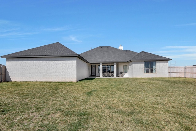 back of house featuring a patio, a yard, fence, and brick siding