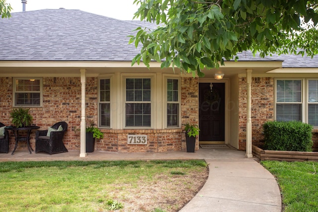 7133 Birkshire Dr, Amarillo, TX 79109 - doorway to property with a shingled roof, a lawn, and brick siding