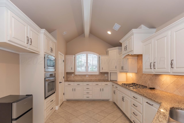 7414 Southbend Dr, Amarillo, TX 79119 - kitchen with appliances with stainless steel finishes, decorative backsplash, white cabinetry, and light tile patterned flooring