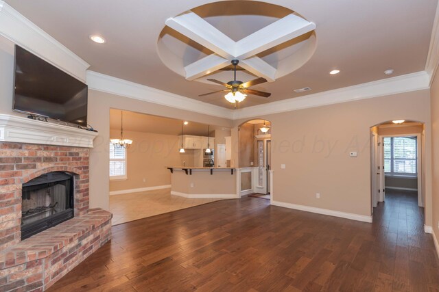7414 Southbend Dr, Amarillo, TX 79119 - unfurnished living room with arched walkways, a fireplace, wood finished floors, ornamental molding, and ceiling fan