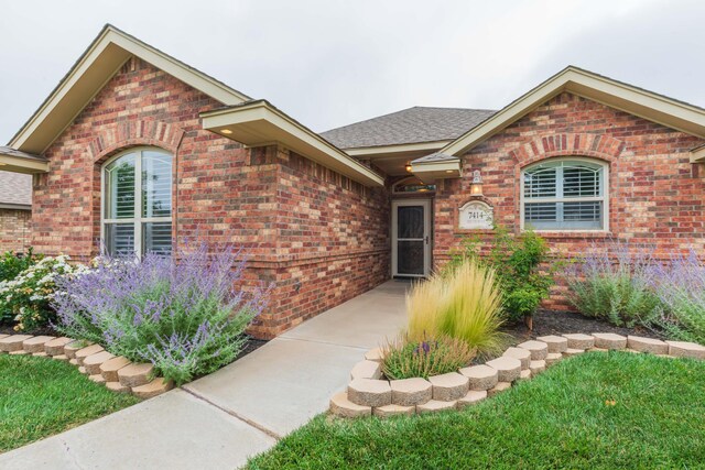 7414 Southbend Dr, Amarillo, TX 79119 - doorway to property featuring brick siding and roof with shingles