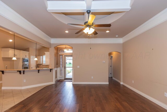 7414 Southbend Dr, Amarillo, TX 79119 - unfurnished living room with arched walkways, a ceiling fan, ornamental molding, wood finished floors, and recessed lighting