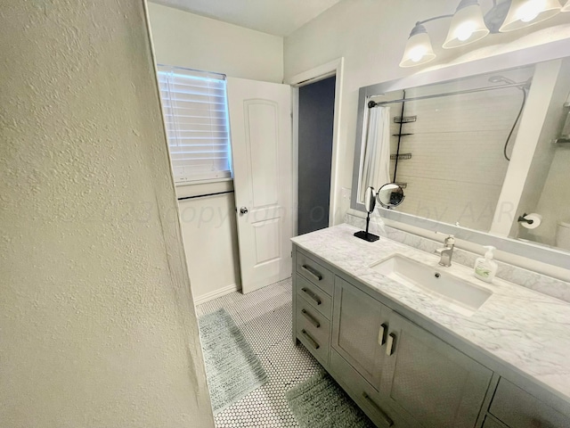 full bathroom with a textured wall, tile patterned floors, vanity, and a shower with curtain
