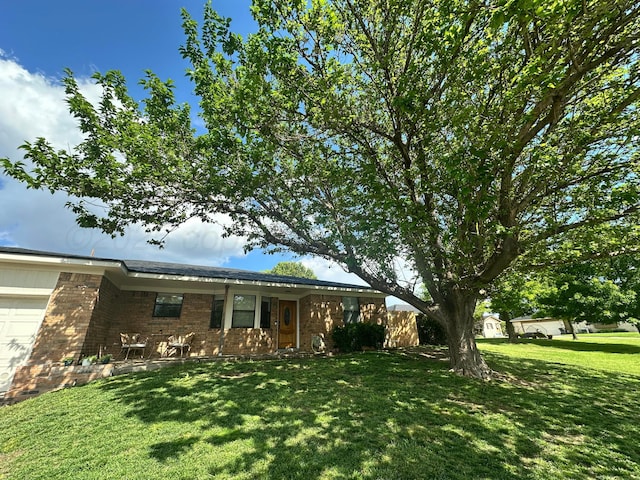 813 Tranquility Ln, Borger, TX 79007 - view of front of home with an attached garage, brick siding, and a front yard
