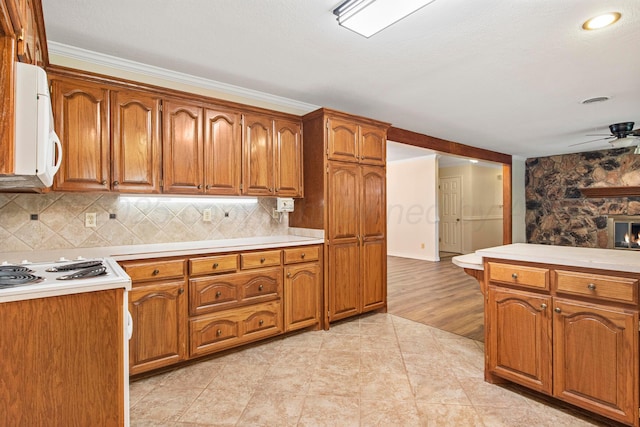 624 Nara Visa Ln, Fritch, TX 79036 - kitchen with white microwave, brown cabinets, light countertops, and a ceiling fan
