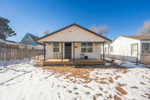 snow covered property with covered porch