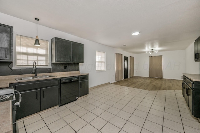 kitchen with black appliances, a sink, light countertops, light tile patterned floors, and dark cabinets