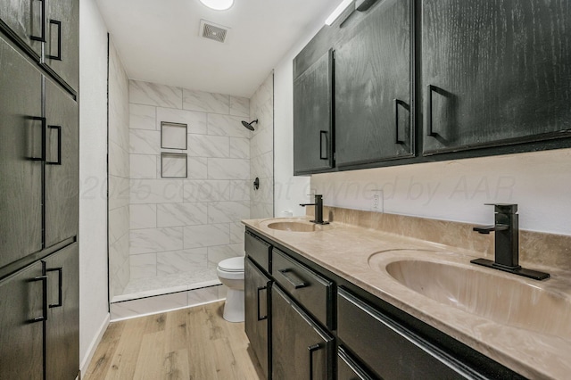 bathroom featuring a stall shower, toilet, visible vents, and a sink