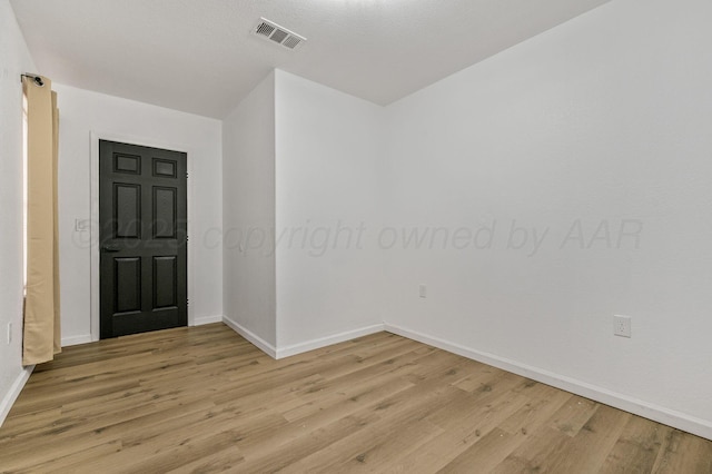 unfurnished room with visible vents, baseboards, and light wood finished floors