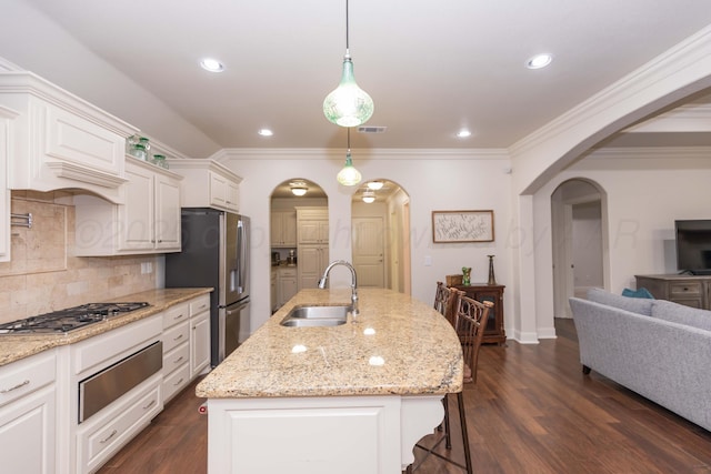 7901 Kingsgate Dr, Amarillo, TX 79119 - kitchen featuring arched walkways, appliances with stainless steel finishes, a warming drawer, backsplash, and dark wood-type flooring