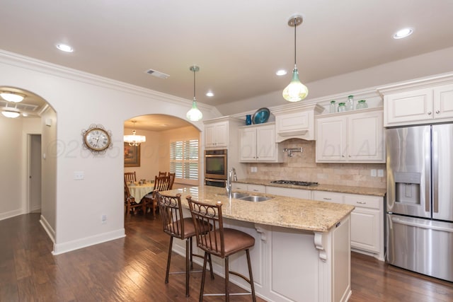 7901 Kingsgate Dr, Amarillo, TX 79119 - kitchen with appliances with stainless steel finishes, arched walkways, tasteful backsplash, crown molding, and dark wood-type flooring