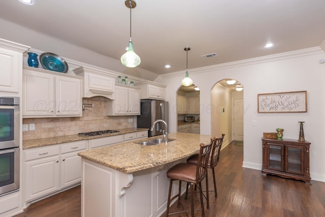 7901 Kingsgate Dr, Amarillo, TX 79119 - kitchen with arched walkways, appliances with stainless steel finishes, tasteful backsplash, ornamental molding, and dark wood finished floors